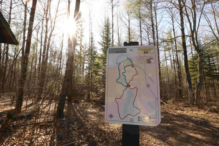 Sign showing the many trail loops with the sun in the background