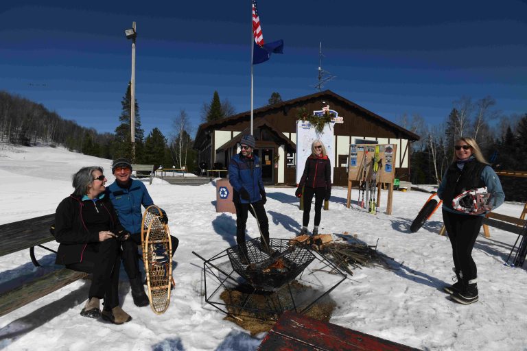 Couples taking a break from snowshoeing around the firepit