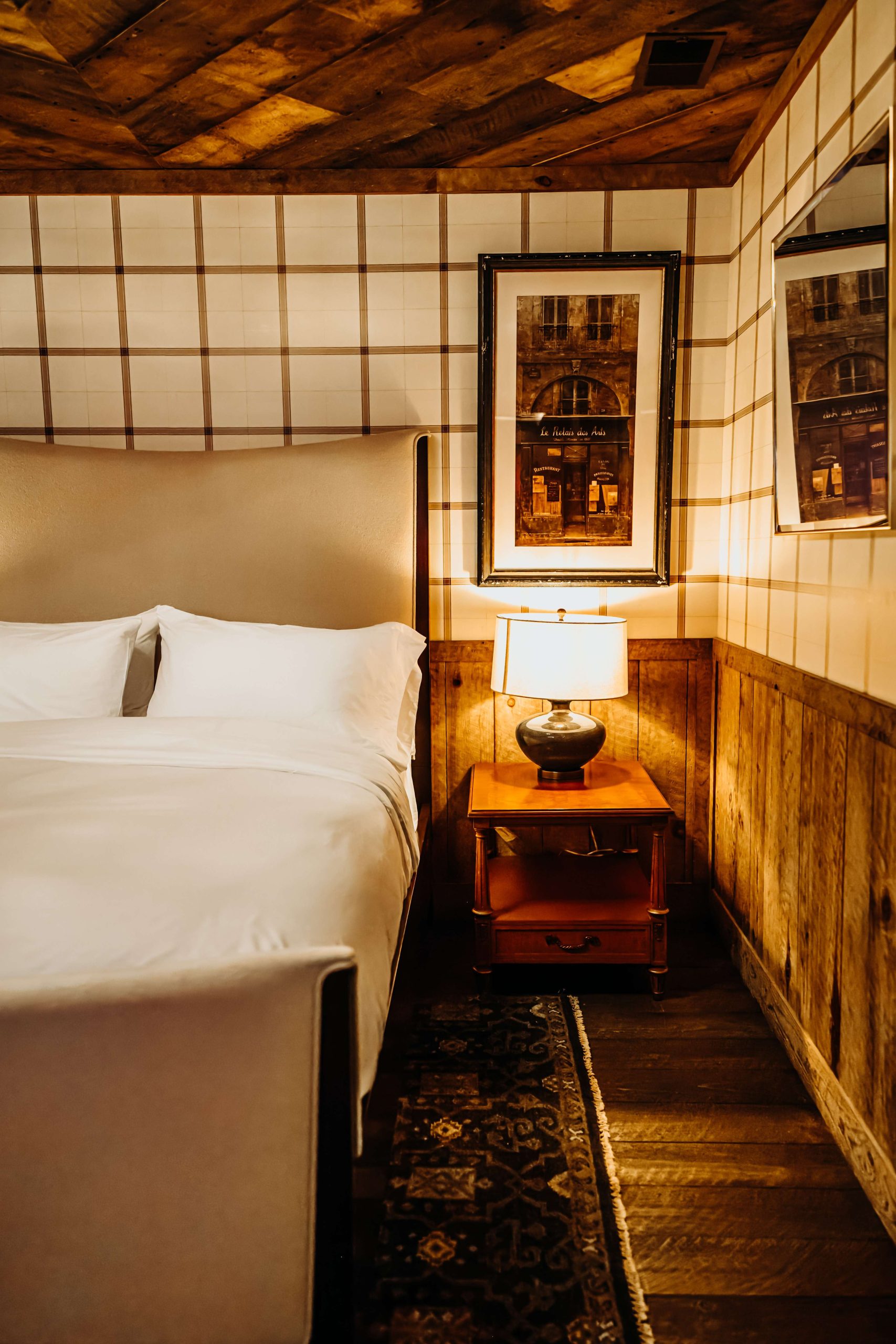 Bootleggers Lodge | Cozy room with bed and night stand at Bootleggers Lodge