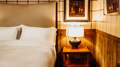 Cozy room with bed and night stand at Bootleggers Lodge