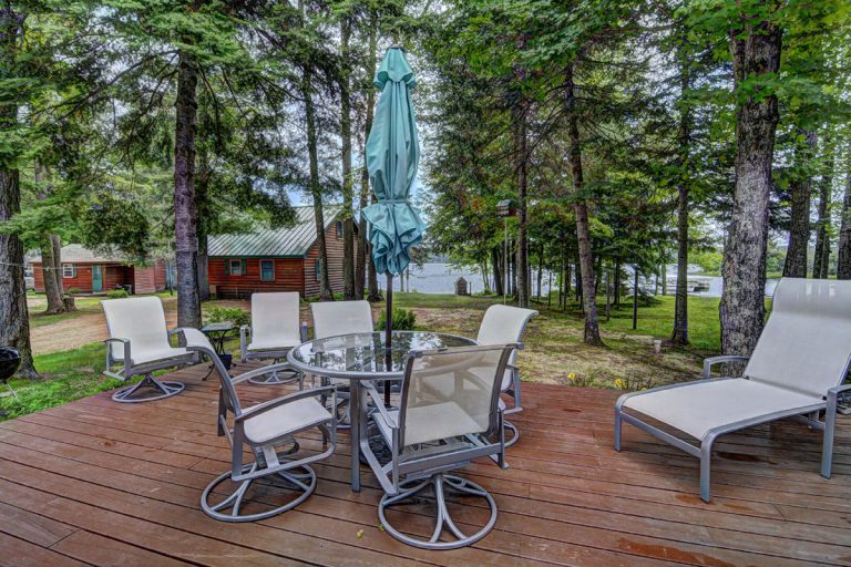 Birch Trail Resort Bed & Breakfast | Patio set sitting on a deck in front of a lodge near the water