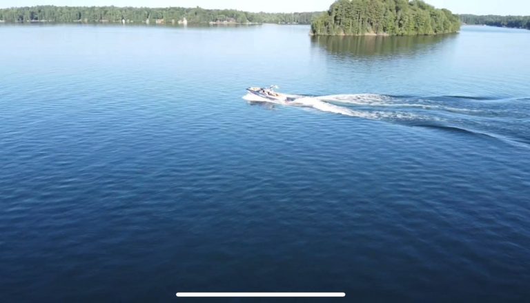 Drone shot of a boat driving on an empty lake