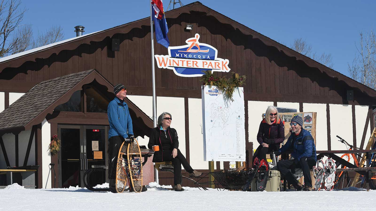 Snowshoers sitting on benches outside Minocqua Winter Park