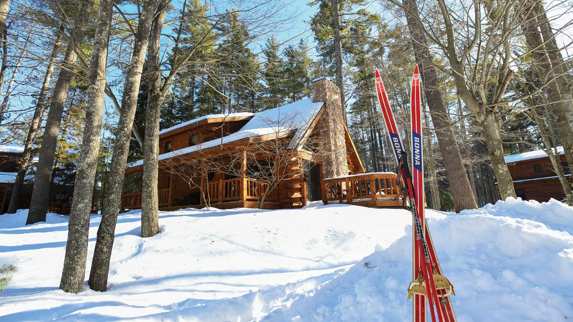 Cabin Covered in snow with skis rising up from the snow
