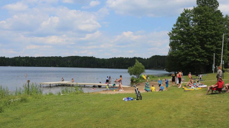 Related Article: Cool down on the water this summer | People enjoying the beach with a dock on a summer day