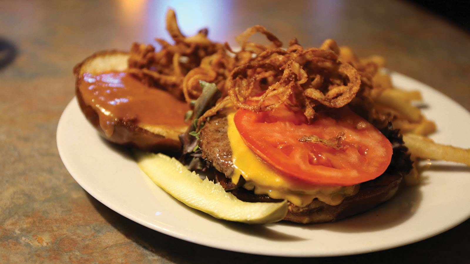 Oneida County fall dining guide | Open burger with cheese, tomatoes, crispy onions and a pickle