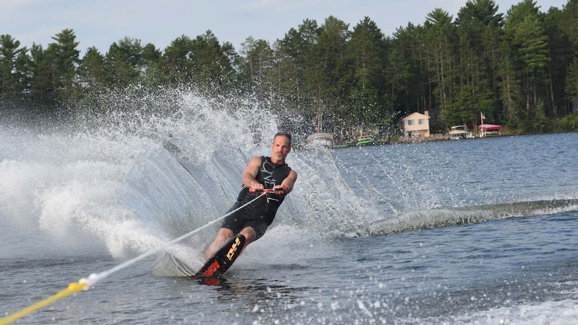 Find outdoor fun in Oneida County | Man Waterskiing in front of Shady Rest Lodge