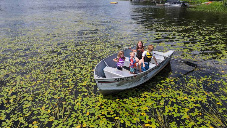 Canoeing, Kayaking & Paddleboarding | Mom and kids in a canoe surrounded by lilly pads