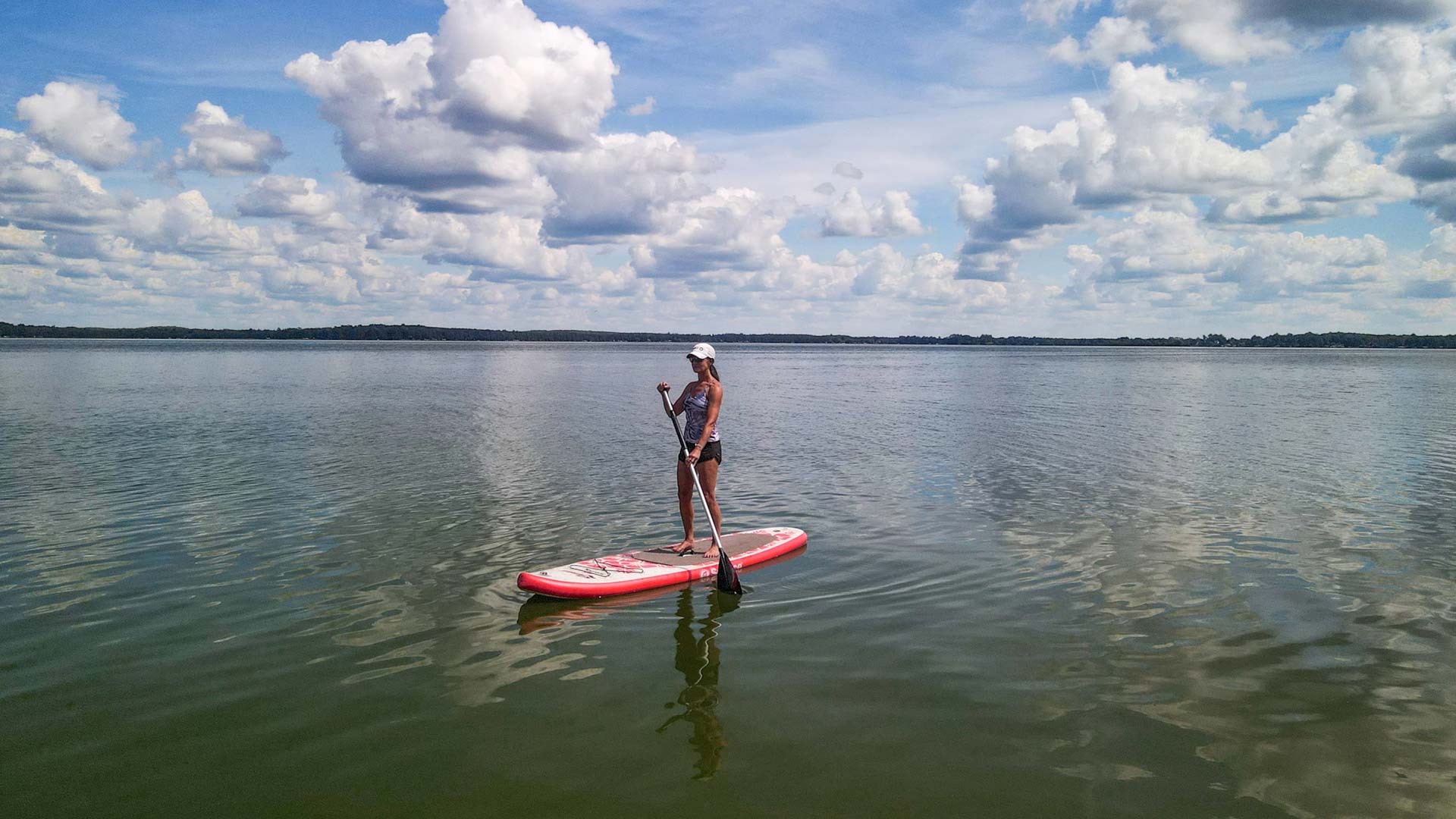Where to go canoeing & kayaking in Oneida County | Woman stand-up paddleboarding on Pelican Lake in Oneida County Wisconsin