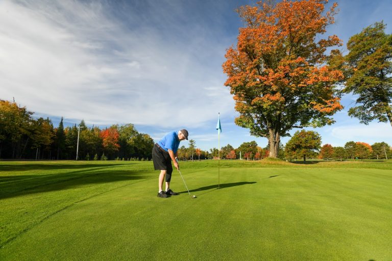 Golfing | A man trying to sink his putt at Big Stone Golf Course during fall