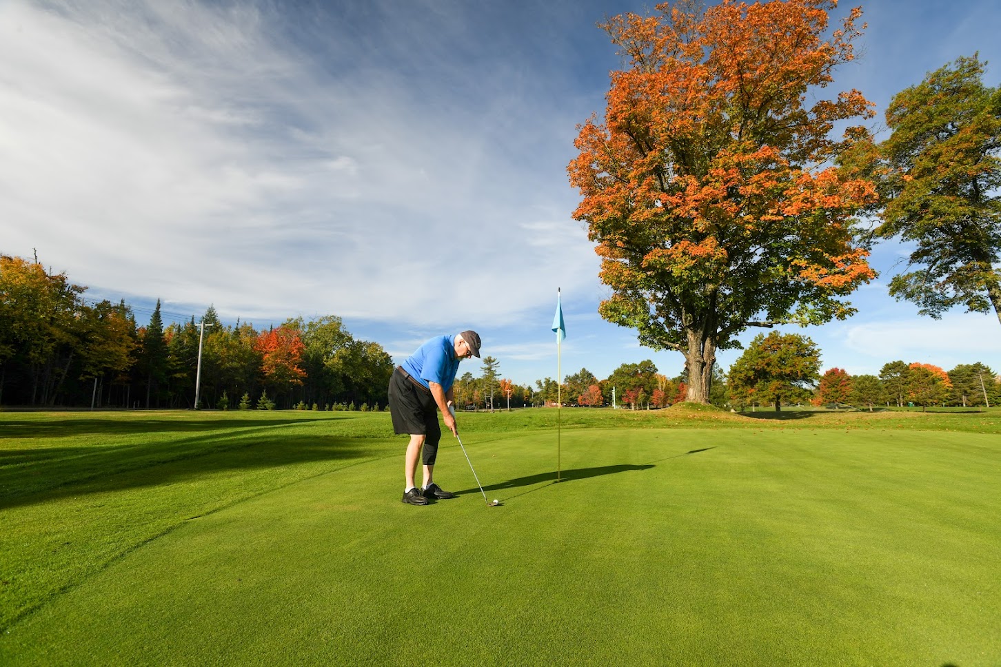 Plan Your Summer Vacation to Oneida County | A man trying to sink his putt at Big Stone Golf Course during fall