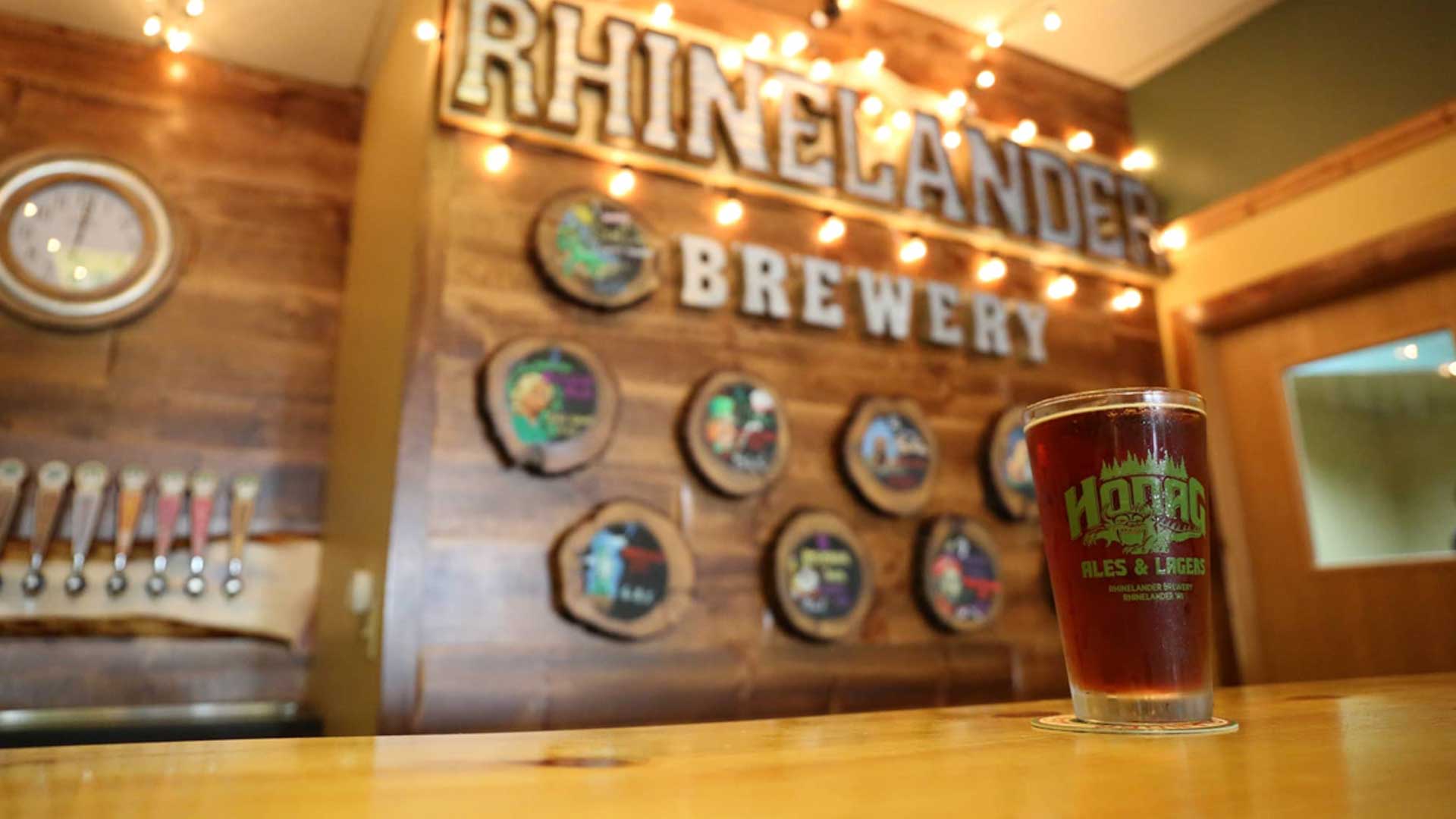 2 breweries to visit in the Northwoods | Beer in a Hodag Ale pint glass at the bar at Rhinelander Brewery taproom in downtown Rhinelander Wisconsin