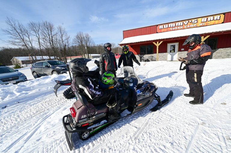 Rummy Bar | Snowmobile parked outside of Rummys Bar in Sugar Camp