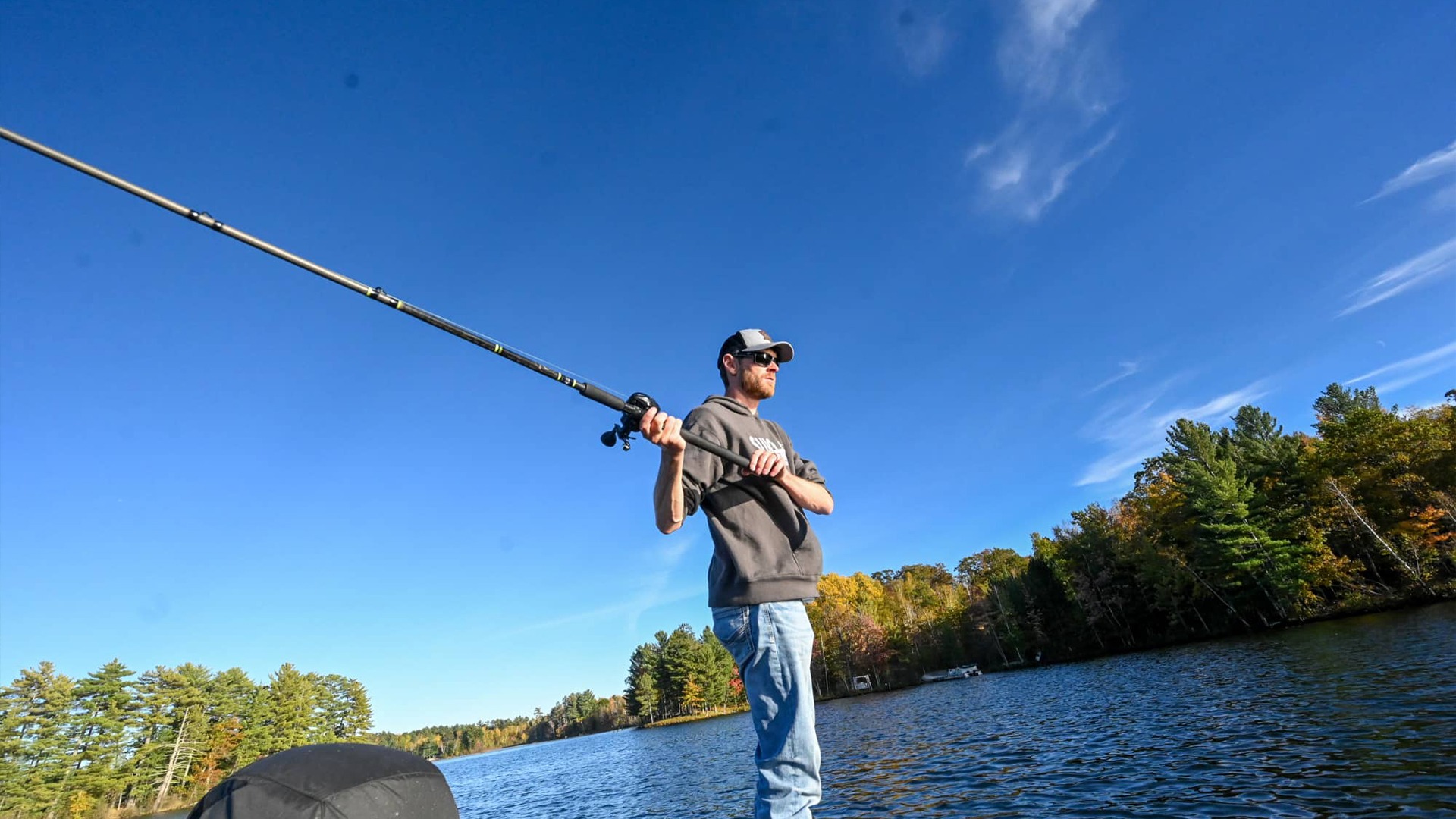 Where to find musky, walleye & more in Oneida County | Man casting a musky pole from a boat on a lake in Oneida County Wisconsin