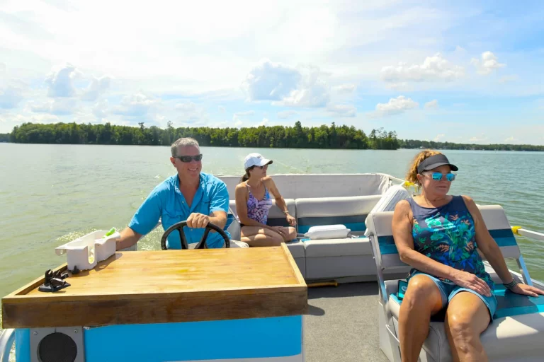 Related Article: What to know about boating in Oneida County | Man driving a pontoon boat with two women as passengers on Pelican Lake in Oneida County Wisconsin